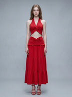 Woman wearing a red halter neck crop top and a tiered maxi skirt.