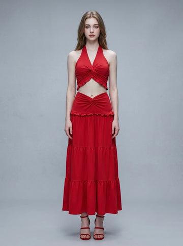 Woman wearing a red halter neck crop top and a tiered maxi skirt.