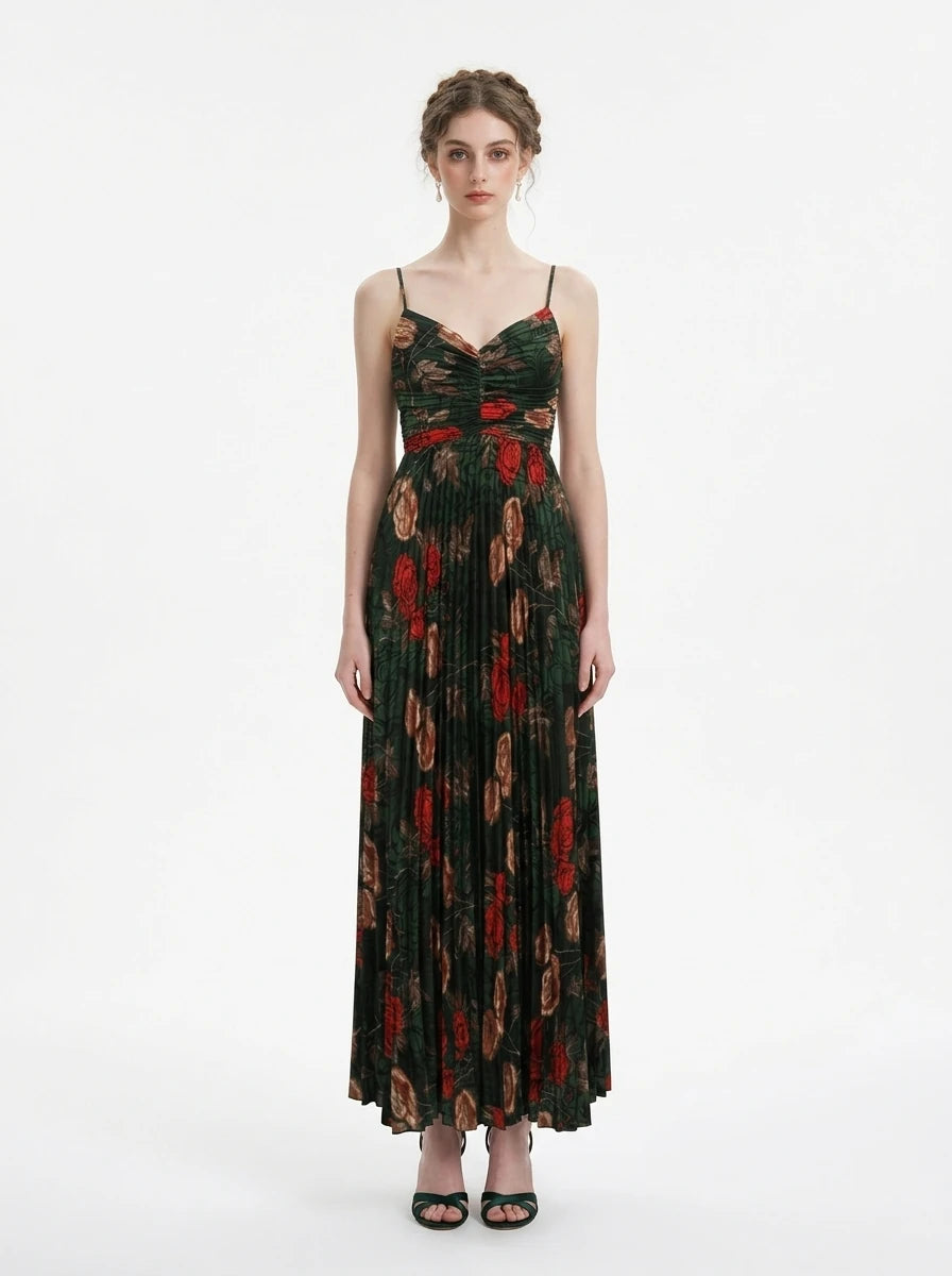 Woman in a dark green floral print maxi dress with spaghetti straps and a pleated skirt, front view
