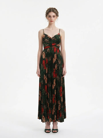 Woman in a dark green floral print maxi dress with spaghetti straps and a pleated skirt, front view