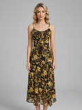 Woman wearing a floral print chiffon midi dress with spaghetti straps and ruffles.