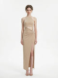 Woman wearing a champagne sparkly knit halter neck maxi dress with a cutout waist and thigh-high slit