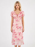 Woman wearing a pink floral print midi dress with a v-neck and tie-front detail.