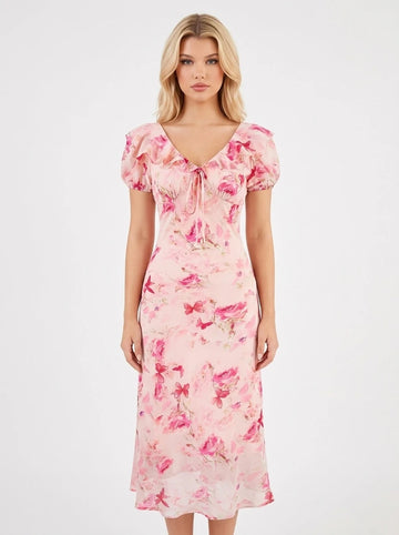 Woman wearing a pink floral print midi dress with a v-neck and tie-front detail.