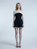 Woman in a black off-the-shoulder dress with white trim, front view