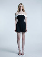 Woman in a black off-the-shoulder dress with white trim, front view