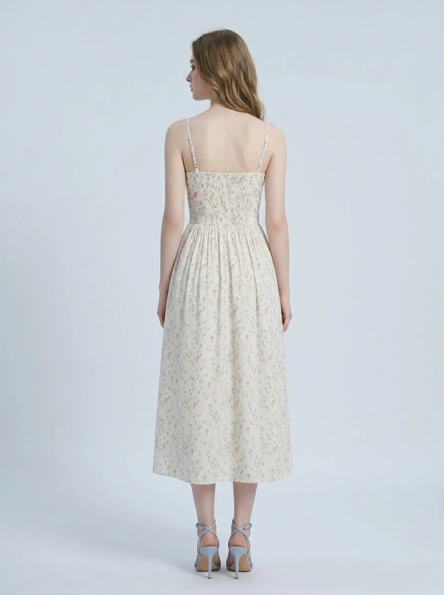 Woman wearing a floral print midi dress with spaghetti straps and a square neckline.