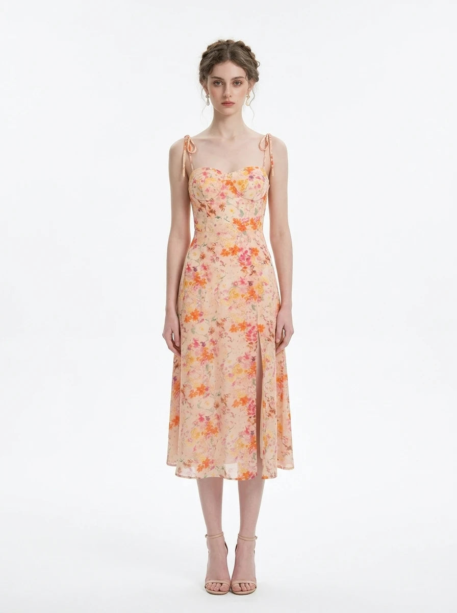 Woman wearing a peach floral print midi dress with sweetheart neckline and tie shoulder straps