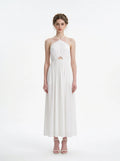 Woman wearing a white halter neck midi dress with a cut-out detail and empire waist