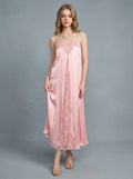 Woman wearing a pink satin slip dress with lace detailing on the front and back.
