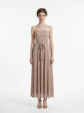 Woman wearing a strapless metallic knit A-line maxi dress with a self-tie belt