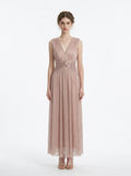 woman in a rose gold metallic a-line maxi dress with a v-neckline and ruched empire waist
