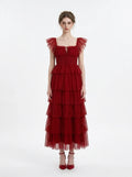 Woman wearing a red tiered tulle dress with ruffled cap sleeves and a square neckline