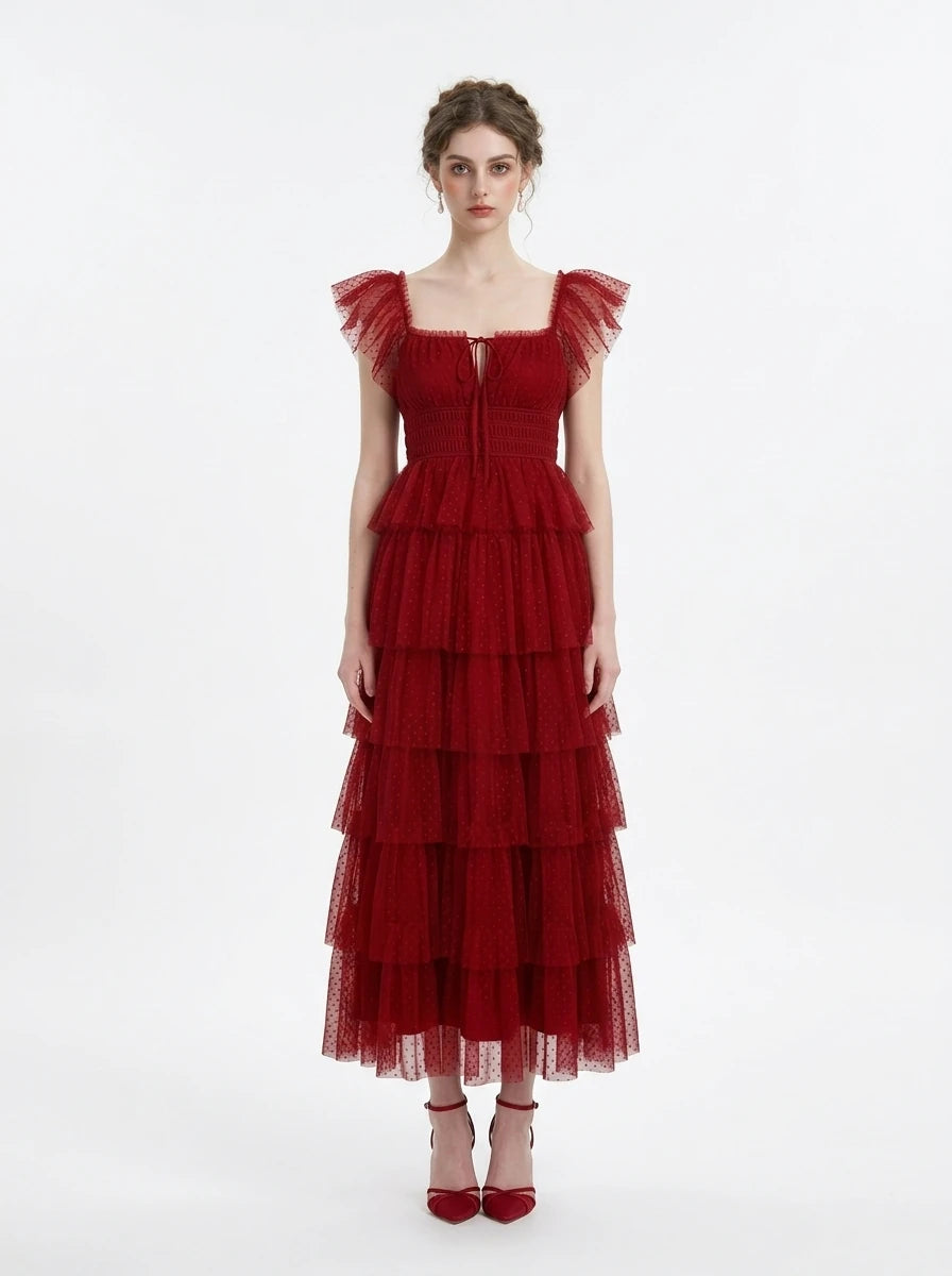 Woman wearing a red tiered tulle dress with ruffled cap sleeves and a square neckline