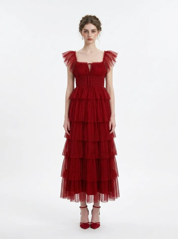 Woman wearing a red tiered tulle dress with ruffled cap sleeves and a square neckline
