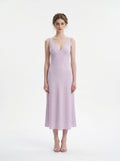 Woman wearing a lilac midi dress with a V-neckline and sleeveless design, standing against a white background.