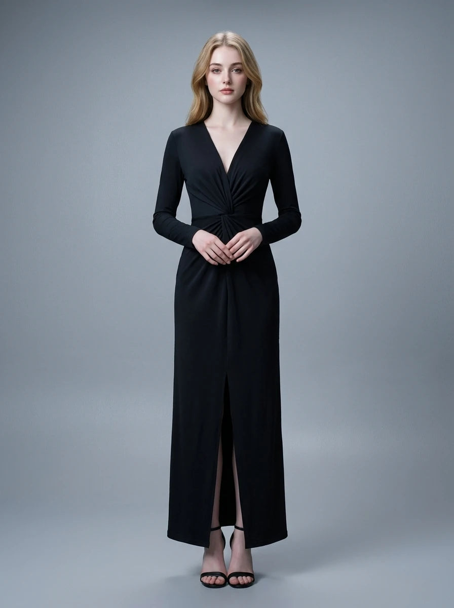 Woman in a black long-sleeved V-neck gown with a front knot and high slit, standing against a grey backdrop.