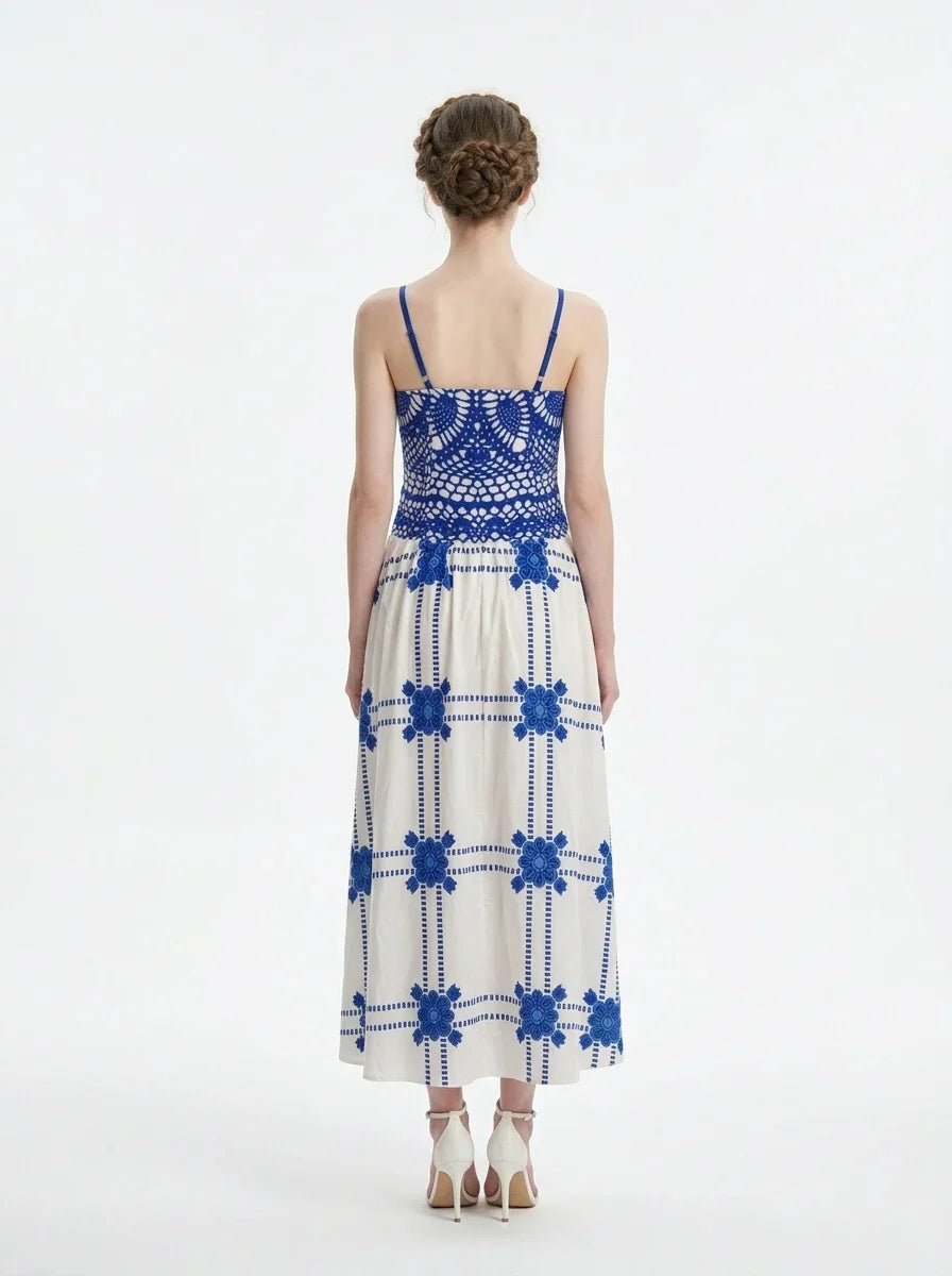 Woman wearing a pink midi dress with a tropical print and spaghetti straps, back view