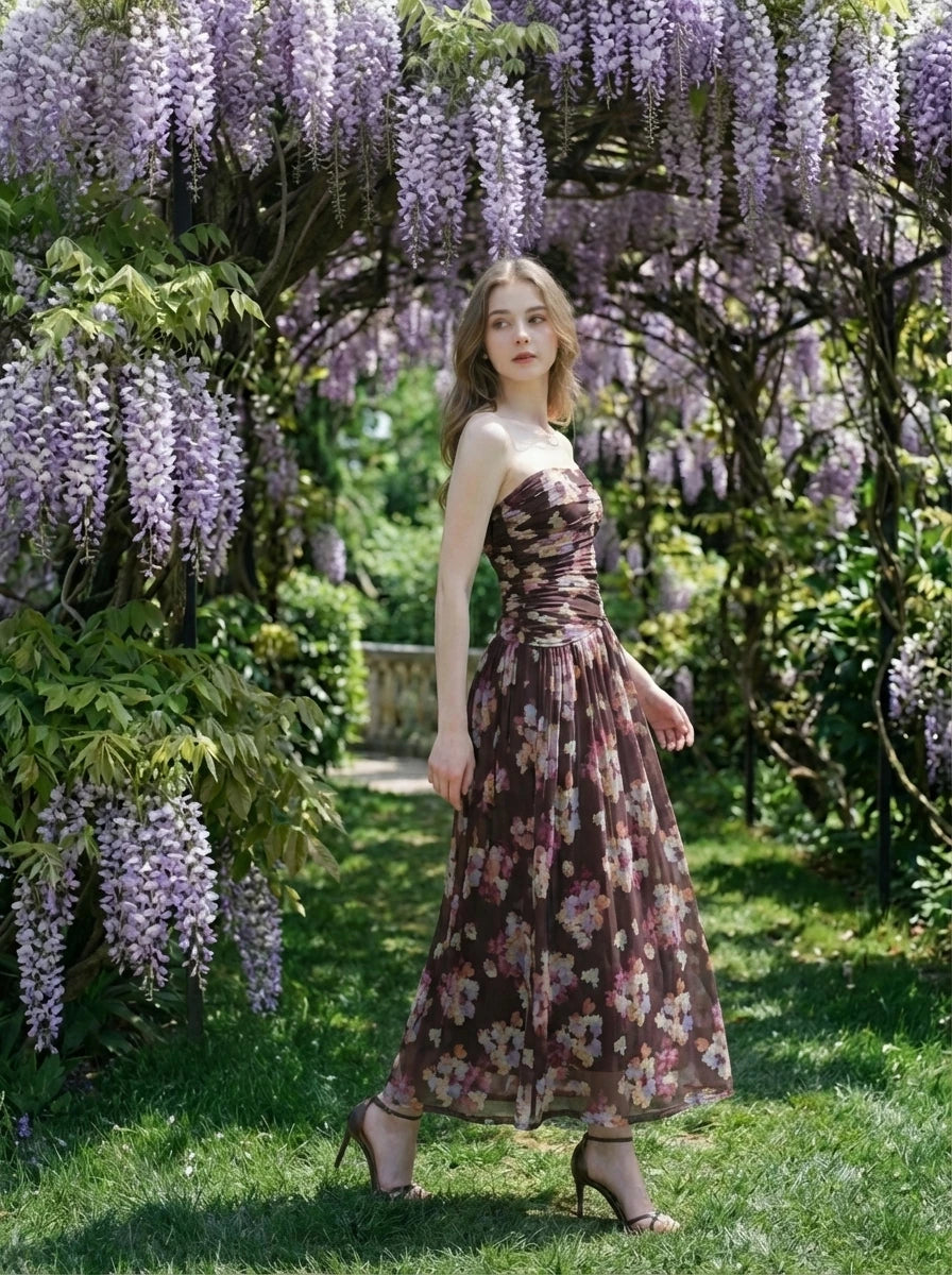Woman in a strapless floral print chiffon maxi dress in a garden setting
