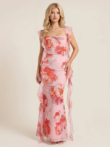Woman wearing a pink floral print chiffon maxi dress with ruffle trim and a square neckline