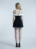 Woman in a black off-the-shoulder dress with white trim, back view
