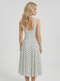 Back view of a woman in a white polka dot fit and flare dress