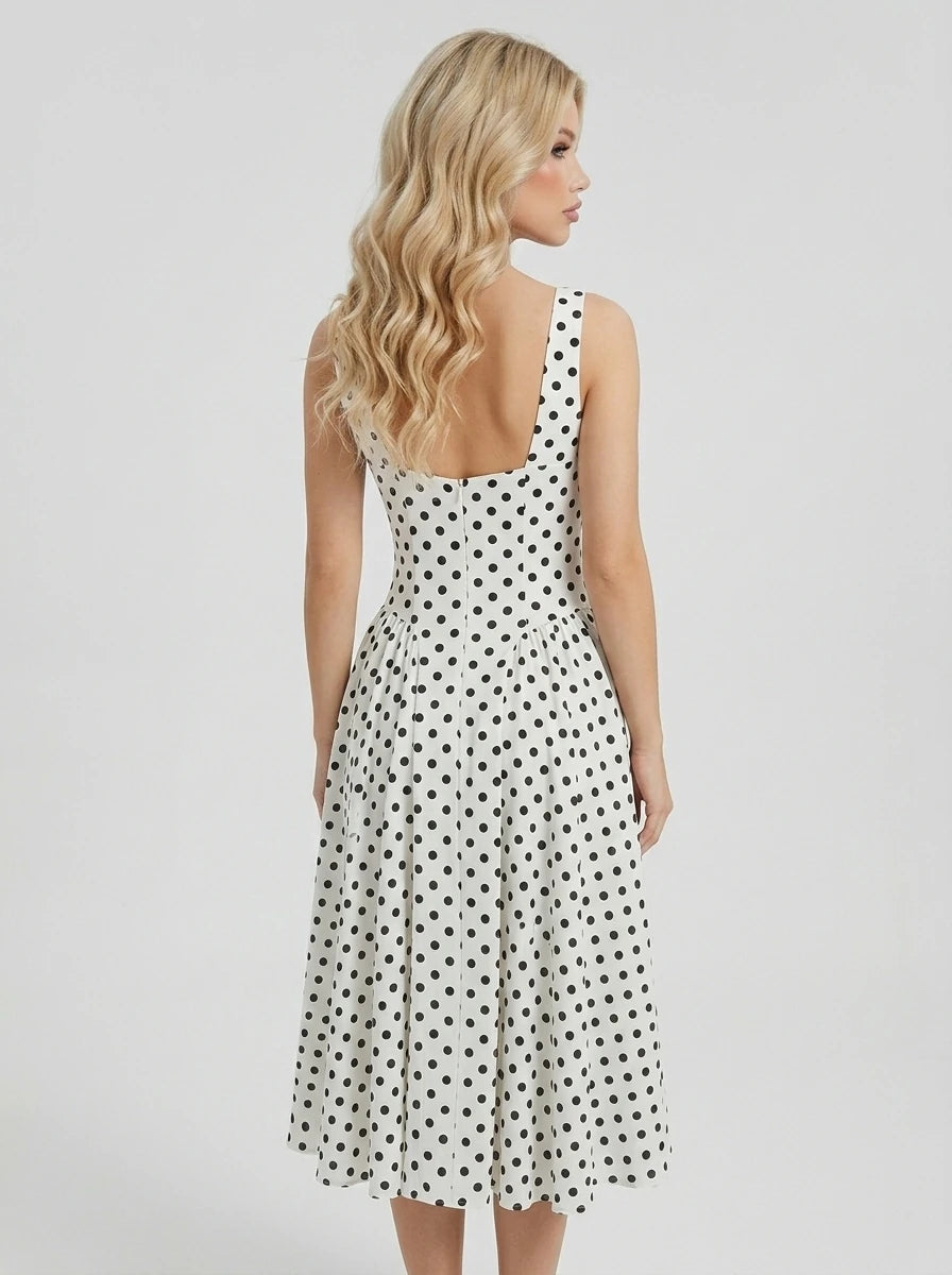 Back view of a woman in a white polka dot fit and flare dress