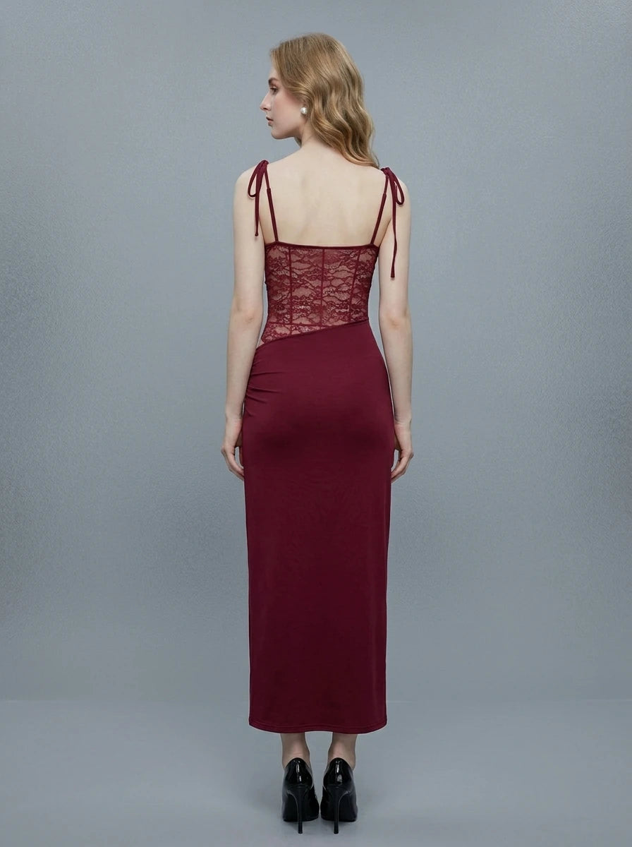 Woman wearing a long burgundy dress with a square neckline and lace detailing on the bodice.