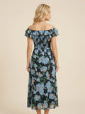 Back view of a woman in a black floral print off-the-shoulder midi dress with blue flowers and ruffle trim