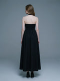back view of a woman in a black midi halter dress with a smocked back