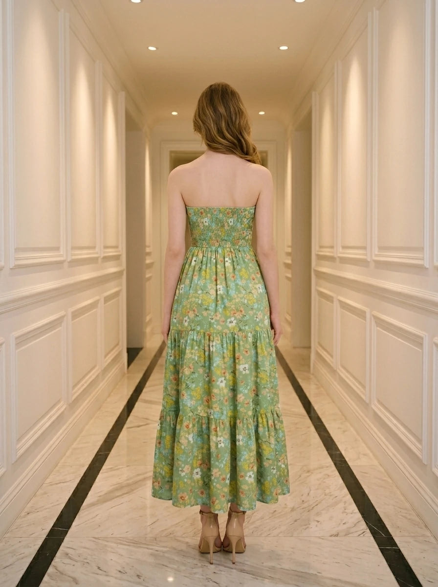 Woman wearing a green floral print strapless maxi dress standing in a hallway.