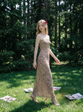 Woman walking in a forest wearing a strapless geometric print maxi dress