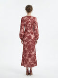 Back view of a woman in a long, floral print, V-neck dress with long balloon sleeves.