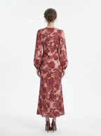 Back view of a woman in a long, floral print, V-neck dress with long balloon sleeves.