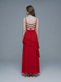 Back view of a woman in a red, floor-length, spaghetti strap dress with a sweetheart neckline and criss-cross back straps