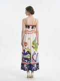 Woman wearing a white midi dress with a colorful graphic print and spaghetti straps from the back