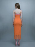 Back view of a woman in an orange slip dress with pink lace trim and sheer hem.