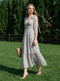 Woman in a floral print midi dress walking on grass in a backyard
