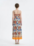 Back view of a woman in a colorful printed A-line midi dress.