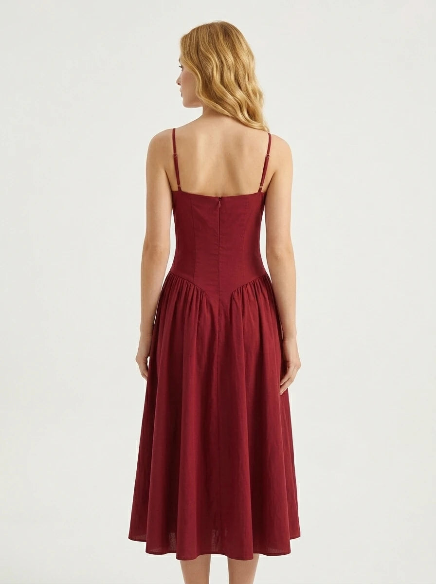 Woman wearing a deep red linen blend midi dress with spaghetti straps and a sweetheart neckline
