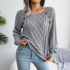 Front view of a woman in a grey cable knit sweater, showing the texture and button details