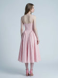 back view of a woman in a pink gingham midi dress