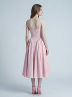 back view of a woman in a pink gingham midi dress