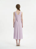 Back view of a woman in a lilac midi dress with a V-neckline and sleeveless design.