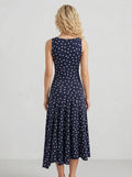 Back view of a woman in a navy blue polka dot midi dress