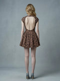 Back view of woman in leopard print fit and flare dress with open back, crew neck, and cap sleeves.