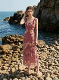 Woman posing by the rocky shore wearing a floral print chiffon maxi dress