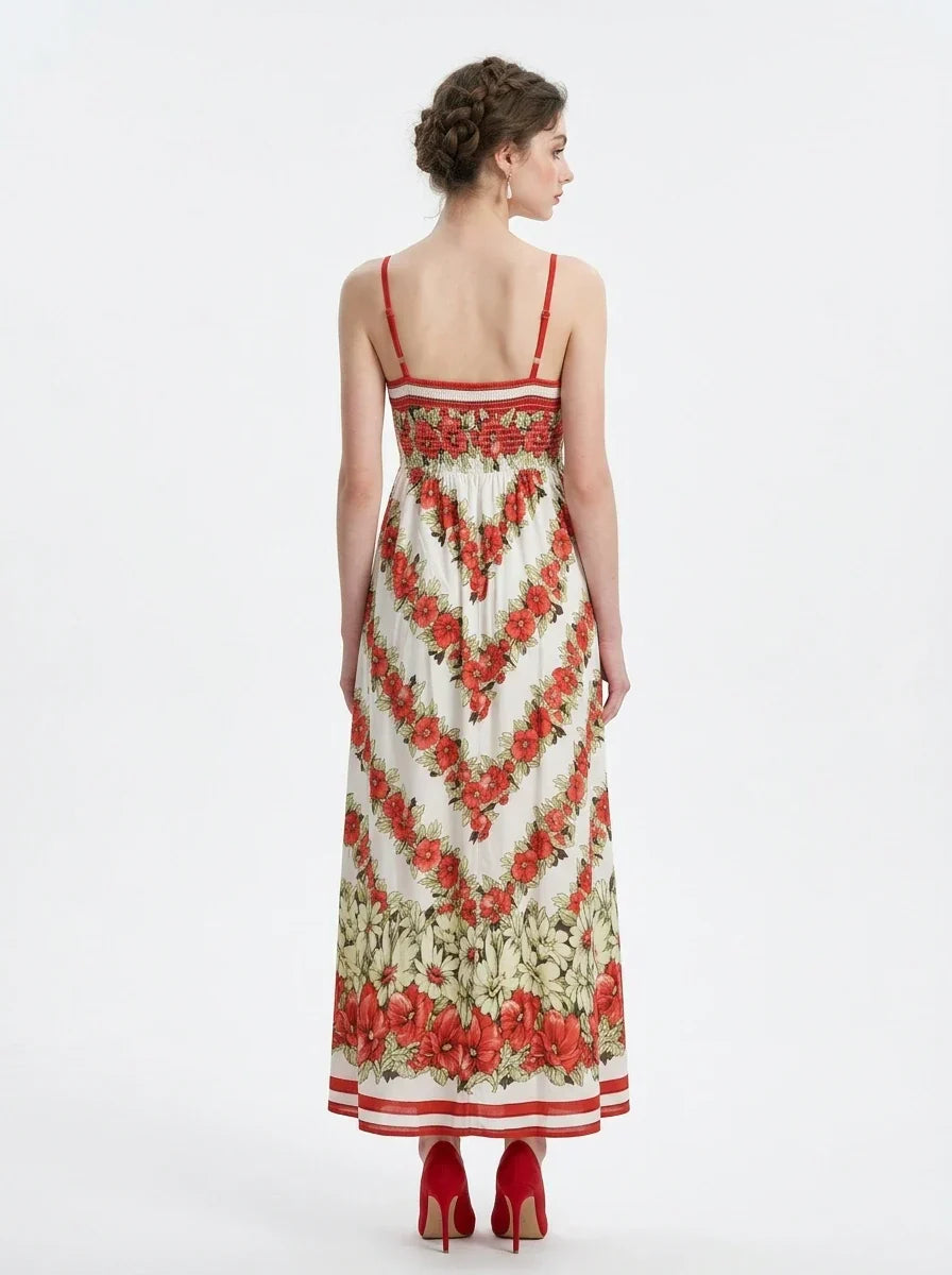 Back view of a woman in a white maxi dress with a red floral print and red trim.