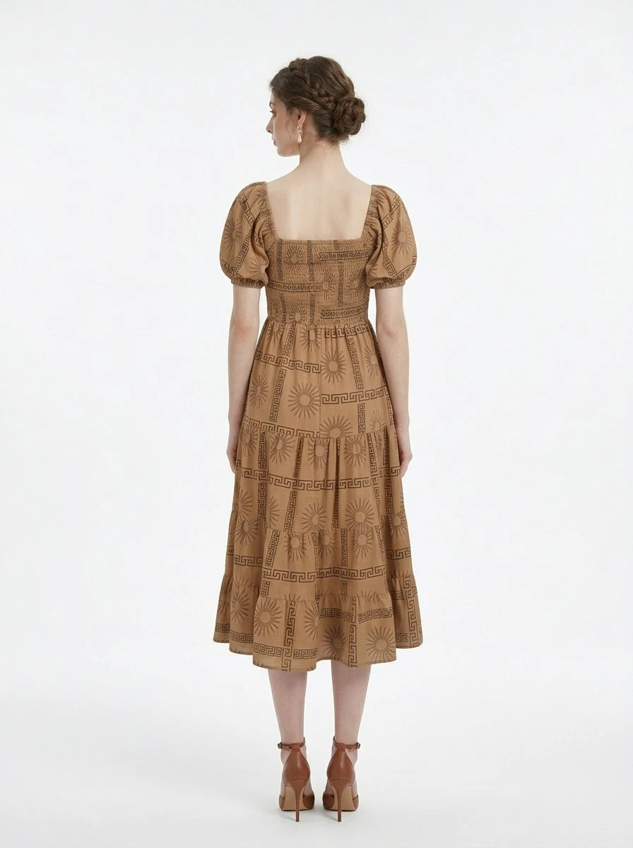 Back view of a woman in a tan midi dress with a smocked bodice and puff sleeves, showcasing the all-over print.