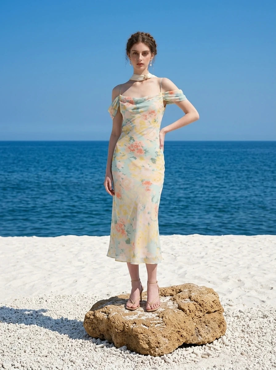 woman wearing a floral print cold shoulder midi dress standing on a beach